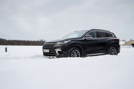 MOSCOW, RUSSIA - FEBRUARY 23, 2021 CHERYEXEED TXL SUV car front side close up view. Black AWD SUV on winter background produced by Chinese company. Chery Exeed TXL Compact SUV car. Crossover at nature.のeditorial素材
