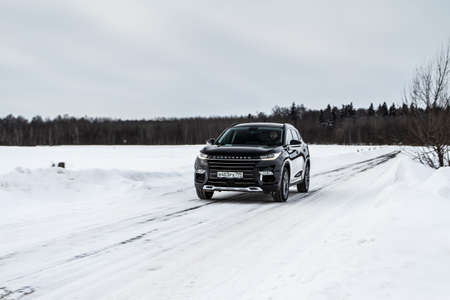 MOSCOW, RUSSIA - FEBRUARY 23, 2021 CHERYEXEED TXL SUV car in motion front side view. Black SUV on nature background produced by Chinese company. Chery Exeed TXL Compact crossover car in motion.のeditorial素材