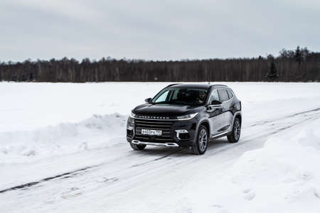 MOSCOW, RUSSIA - FEBRUARY 23, 2021 CHERYEXEED TXL SUV car in motion front side view. Black SUV on nature background produced by Chinese company. Chery Exeed TXL Compact crossover car in motion.のeditorial素材