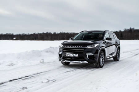 MOSCOW, RUSSIA - FEBRUARY 23, 2021 CHERYEXEED TXL SUV car in motion front side view. Black SUV on nature background produced by Chinese company. Chery Exeed TXL Compact crossover car in motion.のeditorial素材