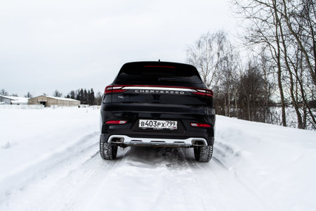 MOSCOW, RUSSIA - FEBRUARY 23, 2021 CHERYEXEED TXL SUV car rear side close up view. Black AWD SUV on...