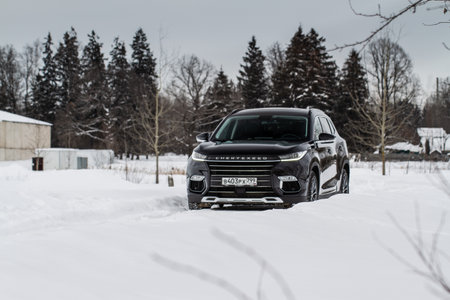 MOSCOW, RUSSIA - FEBRUARY 23, 2021 CHERYEXEED TXL SUV car front side close up view. Black AWD SUV on winter background produced by Chinese company. Chery Exeed TXL Compact SUV car. Crossover at nature.のeditorial素材