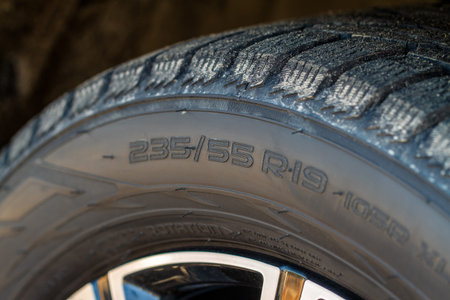 Close up view of tire with tire width, height and wheel diameter designation. Tire size types...