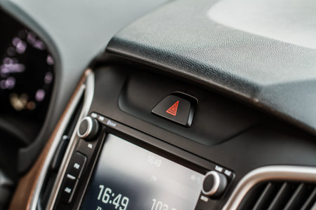 Red triangle hazard light button on car dashboard. Car media buttons dashboard. Detail of a modern...
