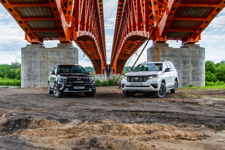 MOSCOW, RUSSIA - MAY 23, 2021 Kia Mohave also called Kia Borrego Second facelift generation HM2 and Toyota Land Cruiser Prado model year 2021. Modern SUV in city and nature background. Front side view.のeditorial素材