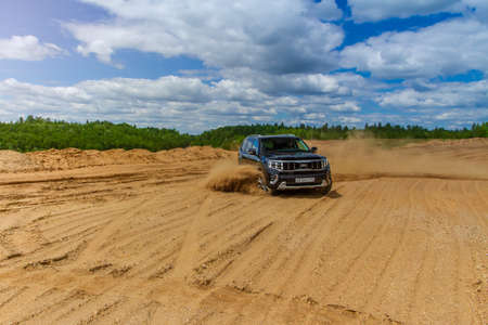 MOSCOW, RUSSIA - JUNE 02, 2021 Kia Mohave also called Kia Borrego Second facelift generation HM2. SUV model year 2021 on nature background. Kia Mohave in motion on the sand.のeditorial素材