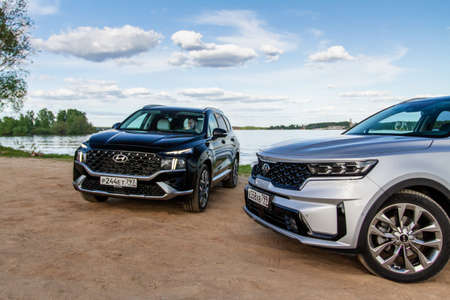 MOSCOW, RUSSIA - MAY 25, 2021 Kia Sorento Fourth generation MQ4 and Hyundai Santa Fe Fourth generation TM. Compact crossovers SUV model year 2021 on nature background. Front side view.のeditorial素材