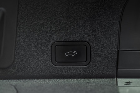 Trunk electric close and lock button close up view. Vehicle interior detail of a modern car.
