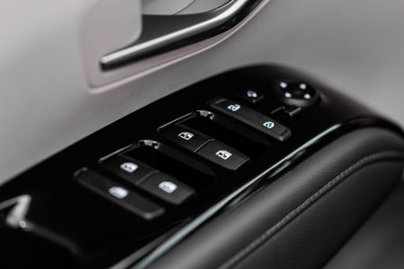 Close up view of button controlling window in modern car interior. Vehicle interior detail. Door...