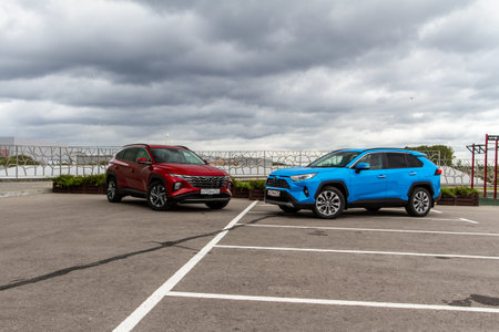 MOSCOW, RUSSIA - SEPTEMBER 9, 2021 New Hyundai Tucson Fourth generation (NX4), and Toyota RAV4 (XA50), a compact crossover SUV car model year 2021 on city background. Exterior front side close up view.のeditorial素材