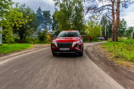 MOSCOW, RUSSIA - SEPTEMBER 9, 2021 New Hyundai Tucson Fourth generation (NX4), a compact crossover SUV car model year 2021 on nature background. Hyundai Tucson in motion view.のeditorial素材
