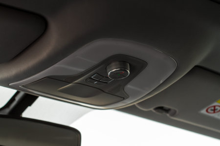 Close up image of the SOS button and car ceiling lamp in a car.