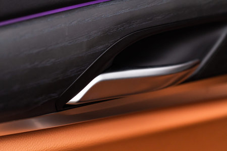 Modern car interior door handle close up. Metallic Car door opener handle inside.