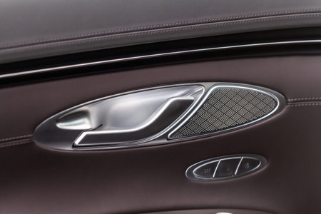 Modern car interior door handle close up. Metallic Car door opener handle inside.