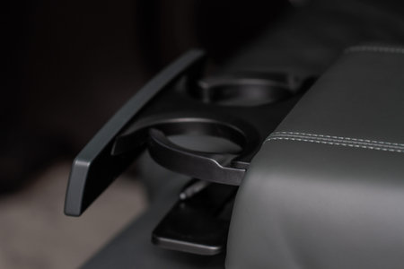 Modern car cup holder for rear seats row. Armrest in the car with cup holder.