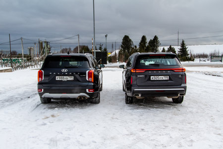 Moscow, Russia - December 18, 2021 Hyundai Palisade LX2 and Exeed VX also called Lanyue exterior view. Crossover SUV. Two modern SUVs in nature background. rear viewのeditorial素材