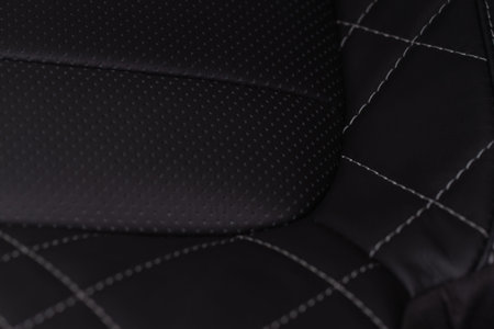 Part of leather car seat. macro. Car leather interior details. High angle view of modern car fabric...