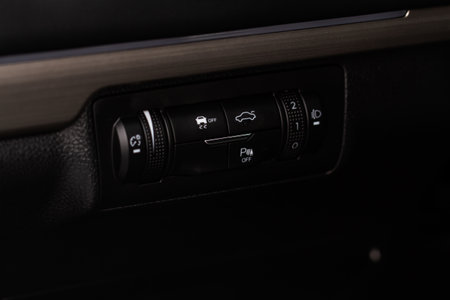 Hand operating ESP (electronic stability program) control close up view. Interior detail of a modern car. ESP button.の写真素材