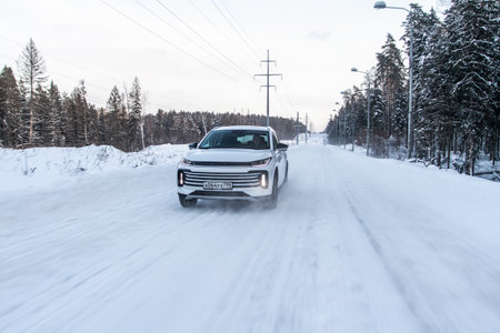 Moscow, Russia - December 25, 2021 Chery Exeed TXL car also called Vantas TX, midsize crossover car. Exterior front-side view on blurred winter background. Exeed car in motion.のeditorial素材