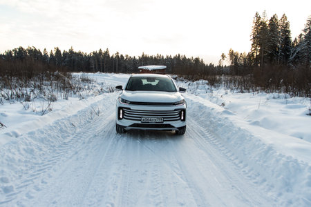 Moscow, Russia - December 25, 2021 Chery Exeed TXL car also called Vantas TX, midsize crossover car. Exterior front-side view on blurred winter background. Exeed car in motion.のeditorial素材