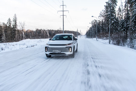 Moscow, Russia - December 25, 2021 Chery Exeed TXL car also called Vantas TX, midsize crossover car. Exterior front-side view on blurred winter background. Exeed car in motion.のeditorial素材