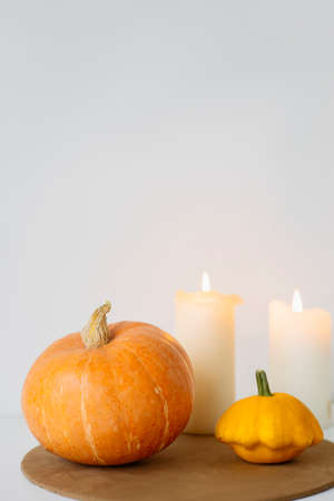 large orange pumpkins on a white background with a candle. Autumn moodの写真素材