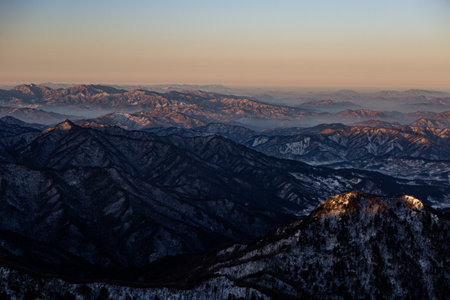 a mountain range covered in snow. a beautiful winter scene on a mountain. a winter mountain infused with dawnの写真素材