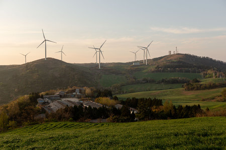 A beautiful farm with wind turbines, mountain and field sunrise