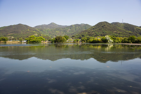landscape view of a lake with mountains and trees in the backgroundの写真素材