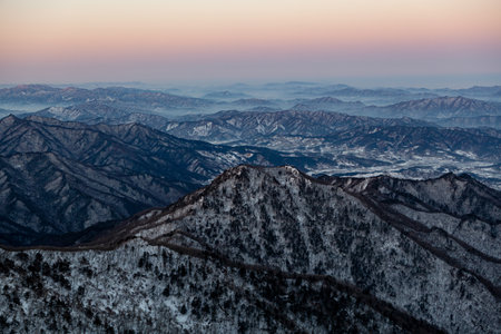 a mountain range covered in snow. a beautiful winter scene on a mountain. a winter mountain infused with dawnの写真素材