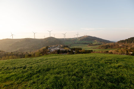 A beautiful farm with wind turbines, mountain and field sunrise