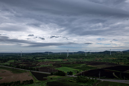 wind turbines in the field with a cloudy sky in the background.の写真素材