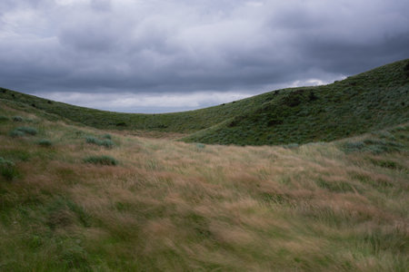 Dramatic skies, ridges, and green pasturesの写真素材