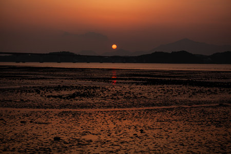 Beautiful sunset on the beach at low tide with reflection in waterの写真素材