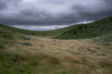 Dramatic skies, ridges, and green pasturesの写真素材