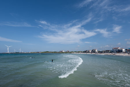 Blue sky, blue sea, surfing person, scenery with wavesの写真素材