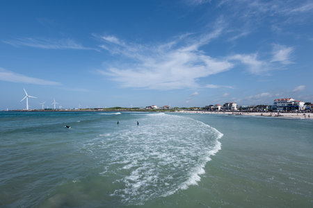 View of the beach and wind turbines on the background of blue skyの写真素材