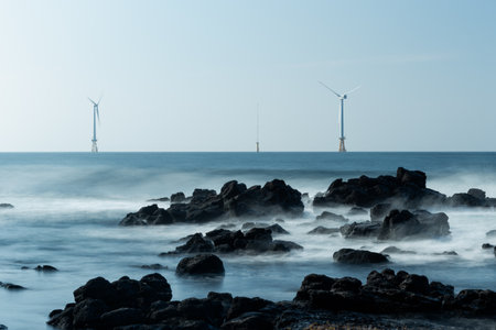 Seascape with wind turbines on the rocks in the sea.の写真素材