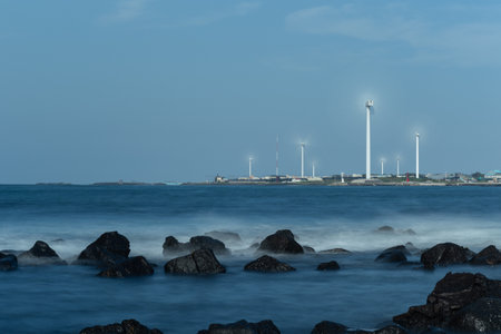 Wind turbines in the sea with blue sky background and long exposure.の写真素材