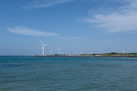 Wind turbines in the sea with blue sky and white cloud background.の写真素材