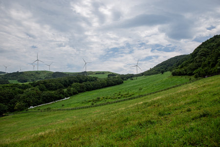 a wind generator on the hills of the expansive pasture of a ranchの写真素材