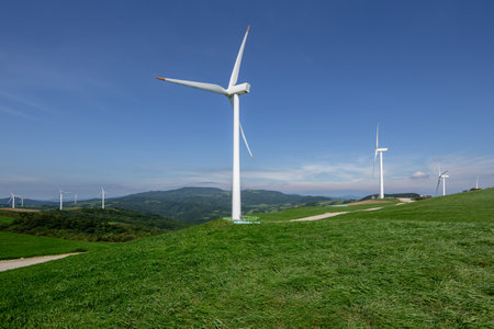 Clean pasture and wind farm landscape under blue skyの写真素材