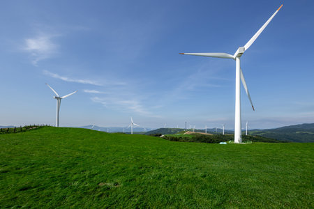 Clean pasture and wind farm landscape under blue skyの写真素材