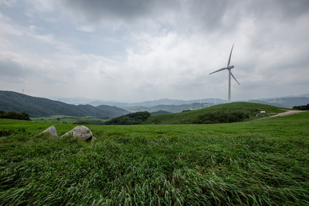 a cloudy sky background, an endless stretch of mountain ranges, and a ranch of wide pasturesの写真素材