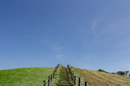 Wooden staircase to the hill with blue sky in the background.の写真素材