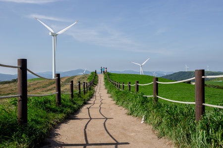 People who tour blue skies, pastures and wind turbinesの写真素材