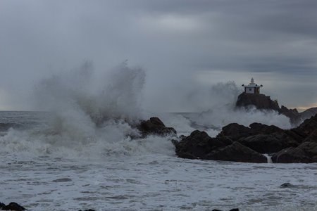 a rock with a small hermitage, a scene of huge waves hitting itの写真素材