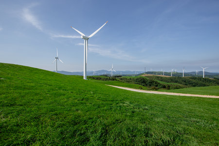 Clean pasture and wind farm landscape under blue skyの写真素材