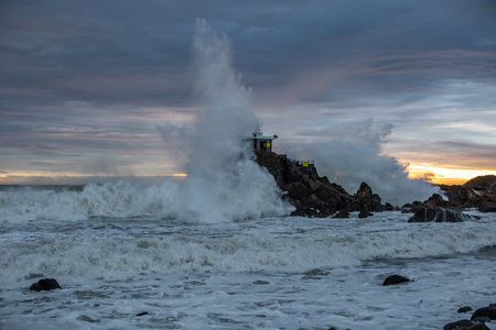 A scene of a storm crashing into a rock and hitting a lighthouseの写真素材