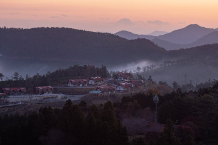 Beautiful sunrise in the mountains with a view of the village and forestの写真素材